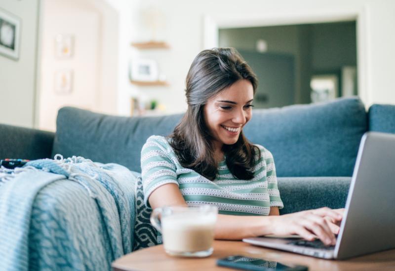 Mujer sonriendo leyendo computadora